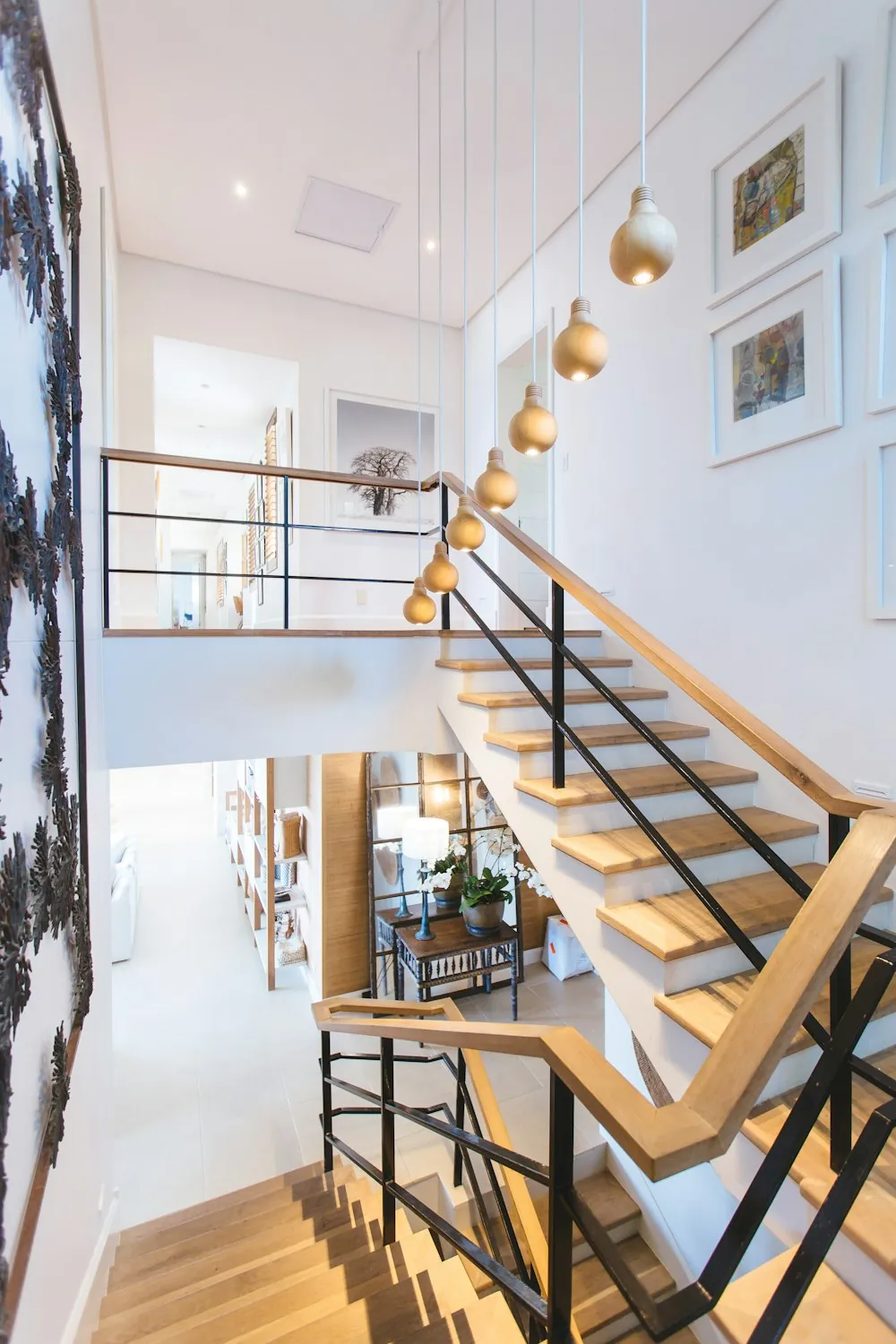A timber and steel staircase rising through a bright stairwell